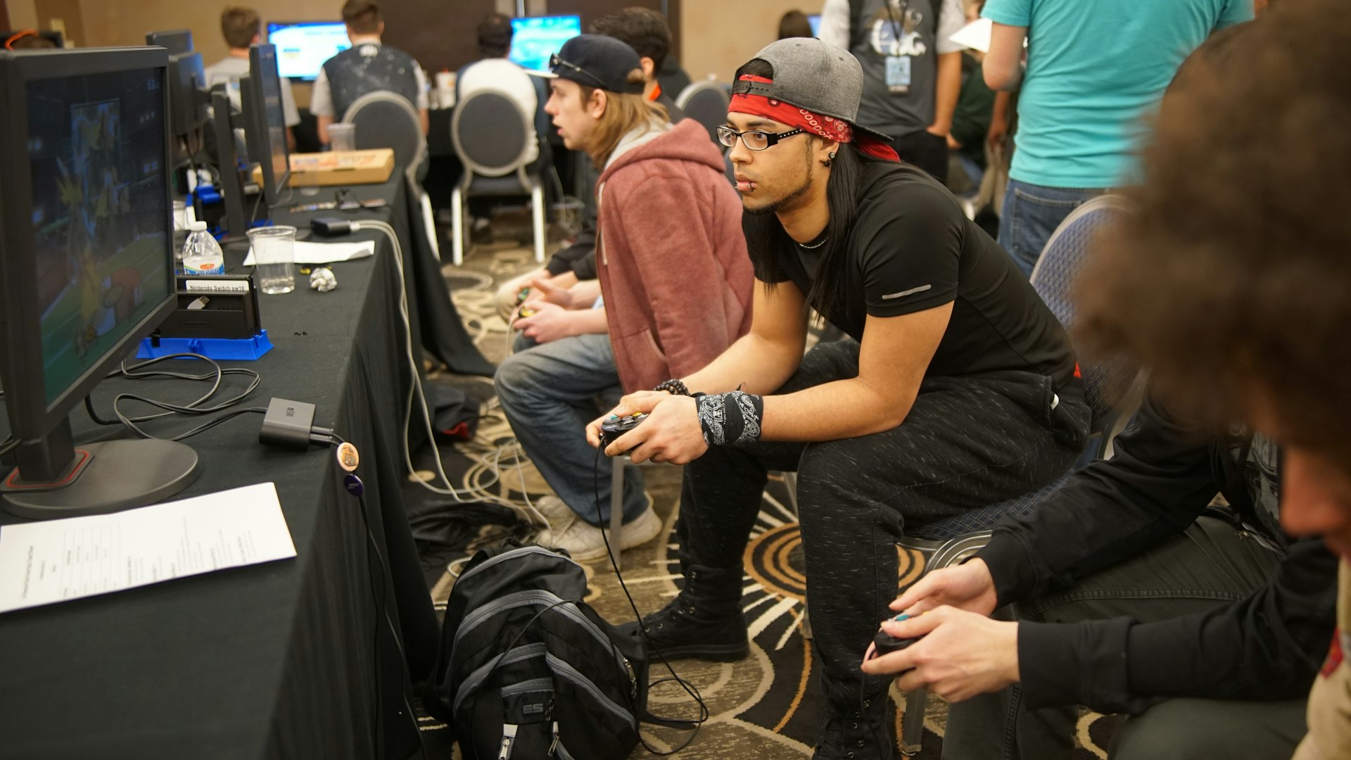 Friends gathered around a table mid-game at the Quserano studio